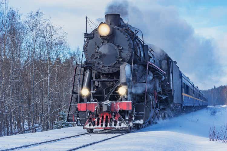 Retro steam train moves at winter morning time.