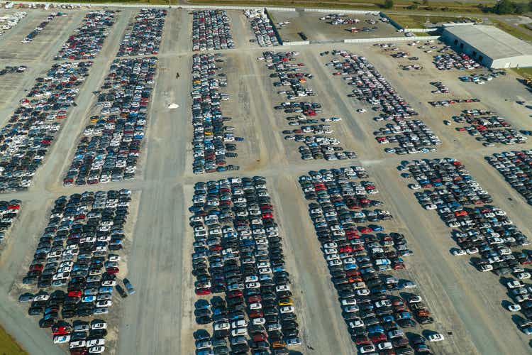 View from above of big parking lot with parked used cars after accident ready for sale. Auction reseller company selling secondhand broken vehicles for repair