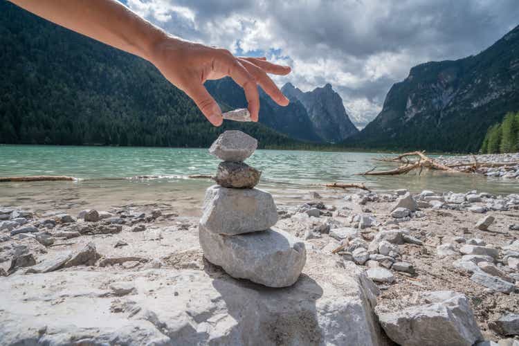 Detail of person stacking rocks by the lake