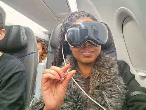 Woman wearing Apple Vision Pro on a plane