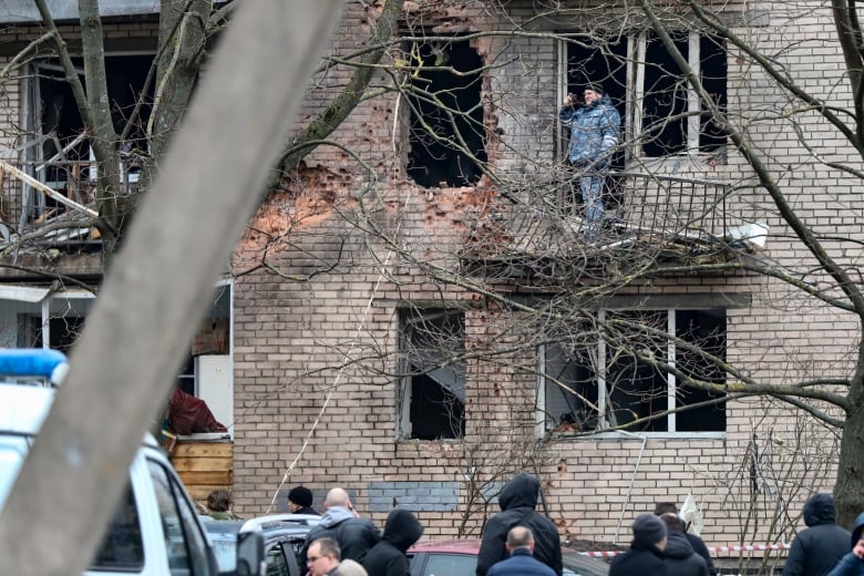 An investigator is seen examining the aftermath of a reported drone attack in St. Petersburg, Russia.