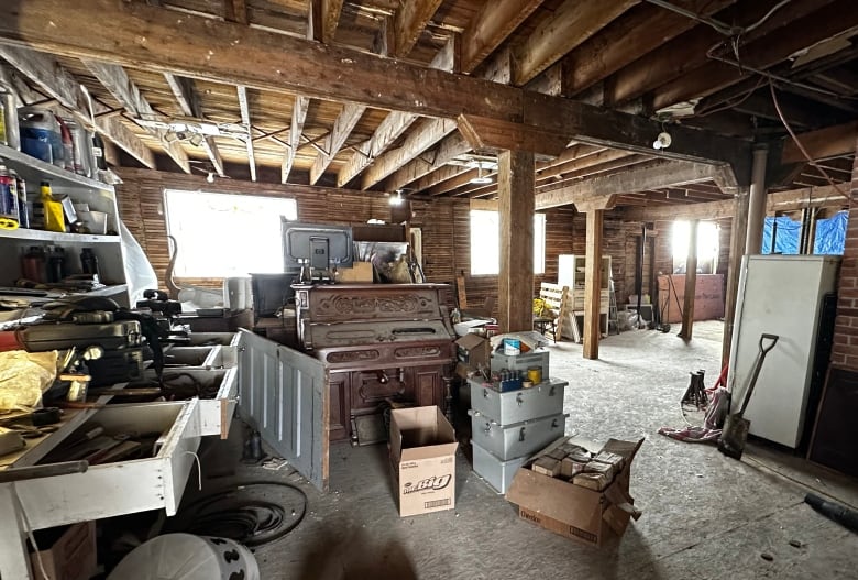 An old dusty piano sits in an old hotel, surrounded by construction materials.