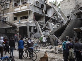 Palestinians inspect the damage of residential buildings after an Israeli airstrike in Rafah, southern Gaza Strip, Sunday, March 24, 2024.