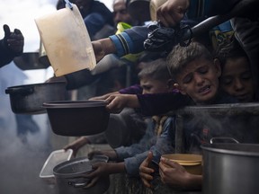 Palestinians line up for a free meal in Rafah, Gaza Strip, Friday, Feb. 16, 2024.