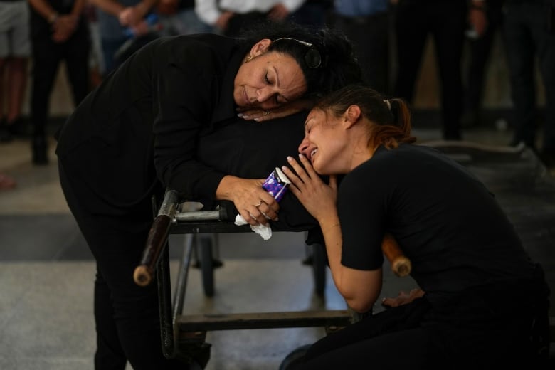 Mourners grieve beside the body of Mapal Adam during her funeral in Tel Aviv, Israel, Wednesday, Oct. 11, 2023. Adam was killed by Hamas militants on Saturday as they carried out an unprecedented, multi-front attack that killed over 1,300 Israelis. 