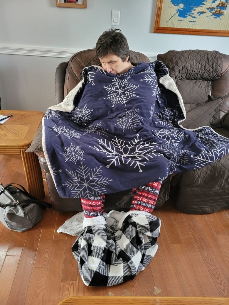 A man covered in blankets and tinfoil.