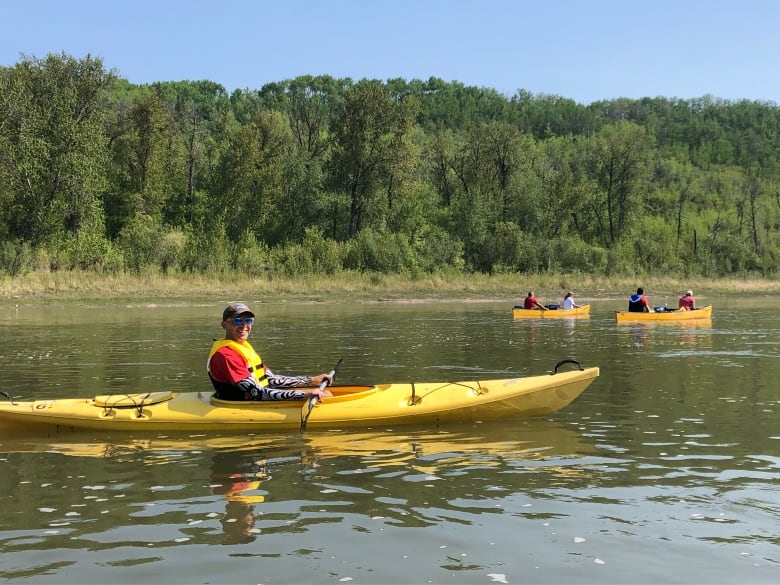 Man in a yellow kayak with a yellow life jacket