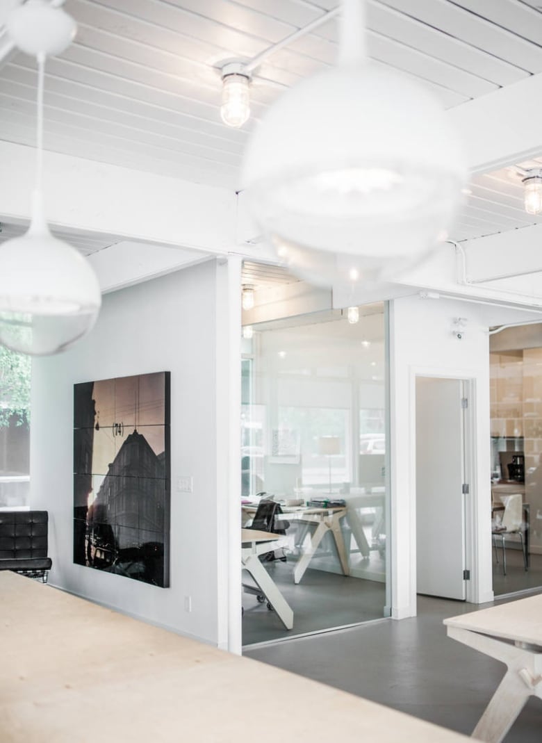 A light-filled office with large lamps hanging from the ceiling.