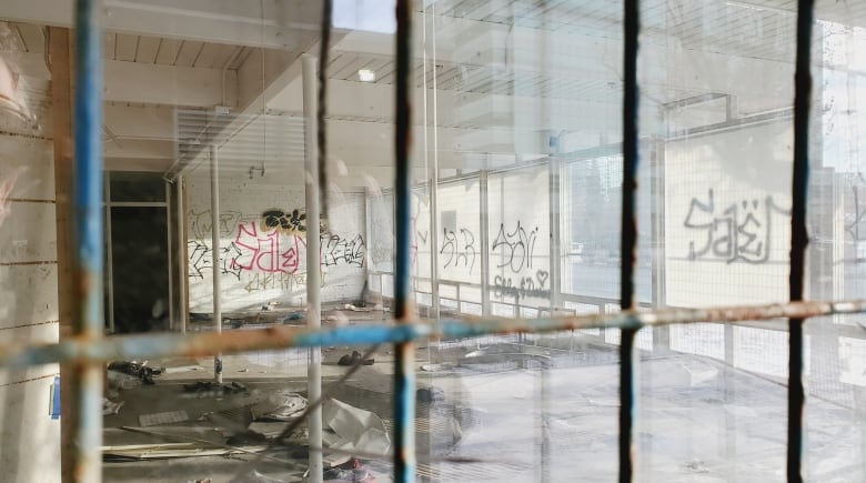 A derelict office seen through metal fencing.