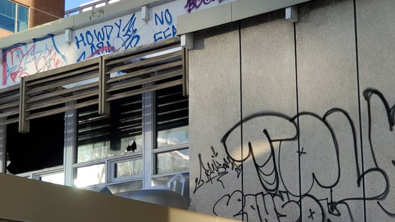 A broken window and graffiti-covered walls.