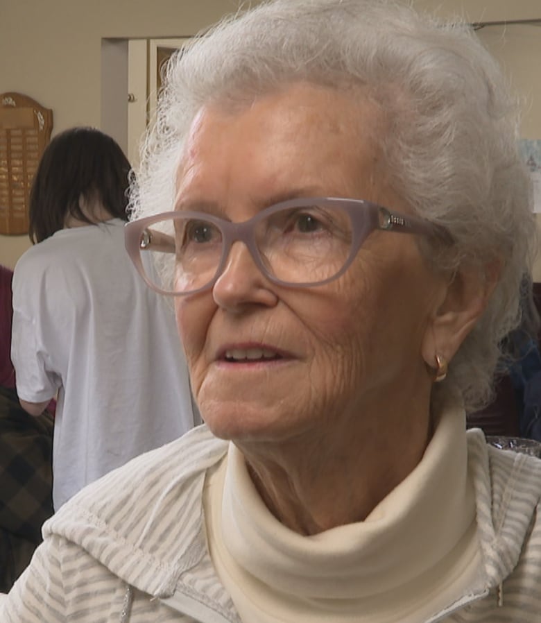 An elderly woman talks to a reporter.