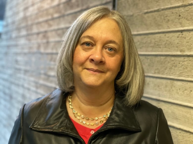 Woman with shoulder length grey hair and a black jacket