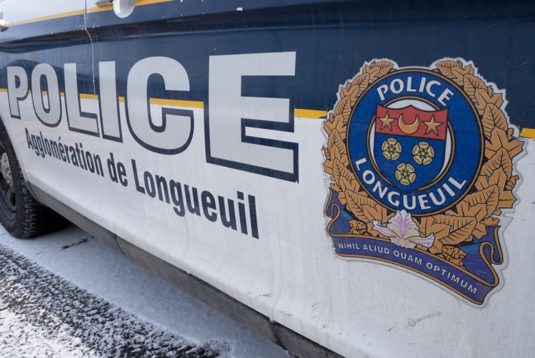 A white and blue car is seen with the Longueuil police logo on the side.