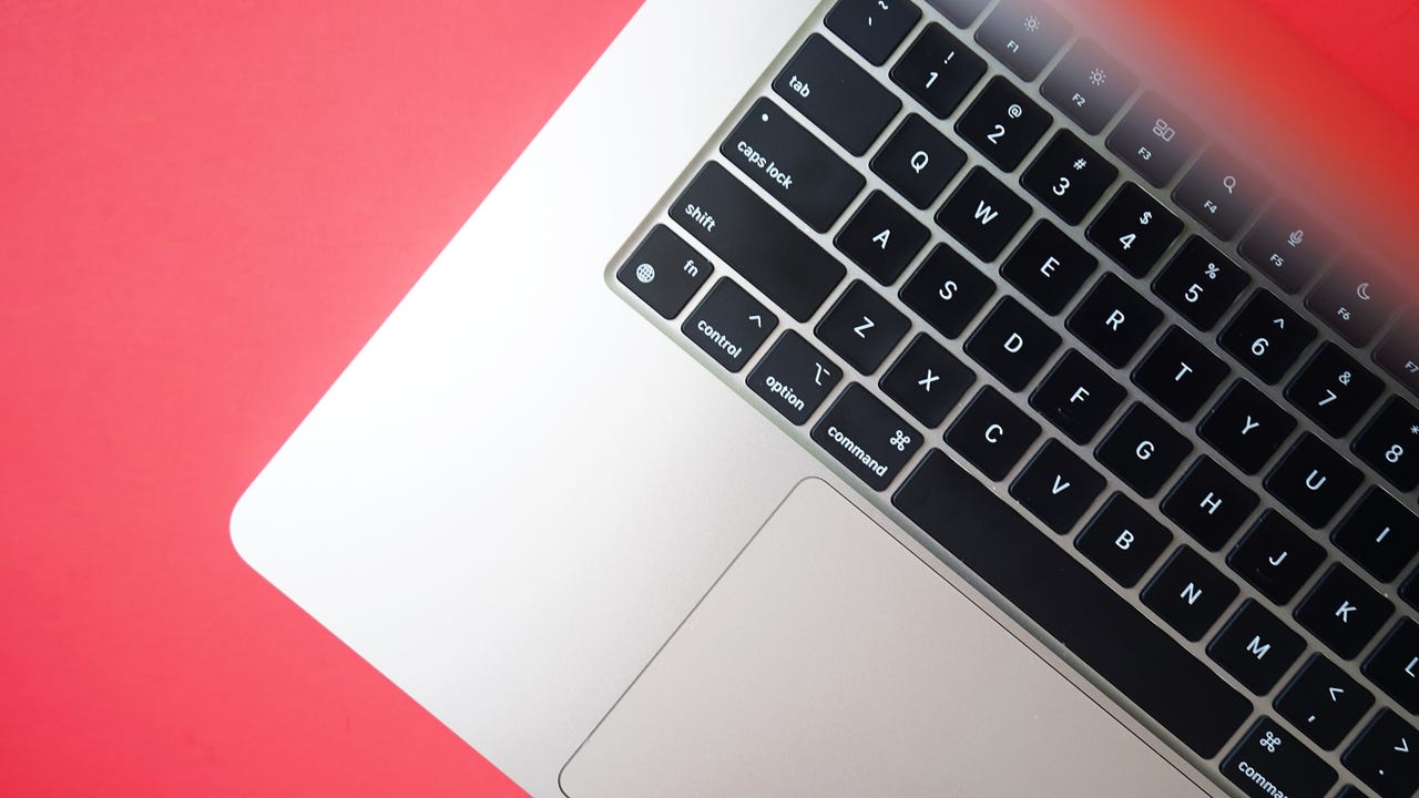 The side of the Apple MacBook Air 15-inch with a red background