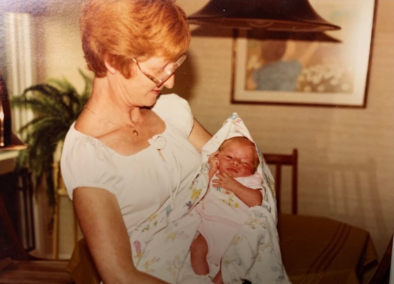 A woman holds a baby in her arms.