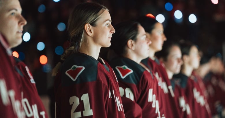 Several female hockey players, with Montreal jerseys, stand on the ice.