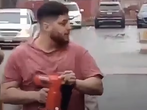 A screenshot from video posted to X of a man with a nail gun during a demonstration at Clark Ave. W. and South Promenade in Thornhill on Sunday, March 3, 2024.