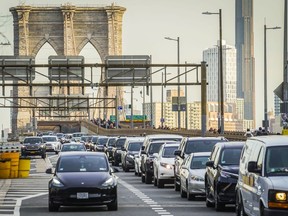 FILE - Traffic enters lower Manhattan after crossing the Brooklyn Bridge, Feb. 8, 2024, in New York. The Biden administration this week is expected to announce new automobile emissions standards that relax proposed limits in the next few years but reach the same strict standards outlined by the Environmental Protection Agency last year.