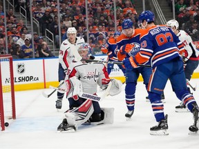 Oilres stand in front of the Capitals net