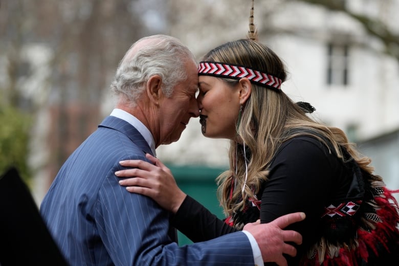 Two people greet each with a traditional Maori greeting