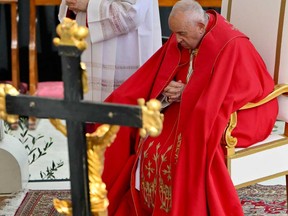 Pope Francis prays during the Palm Sunday mass at St Peter's square in the Vatican on March 24, 2024.