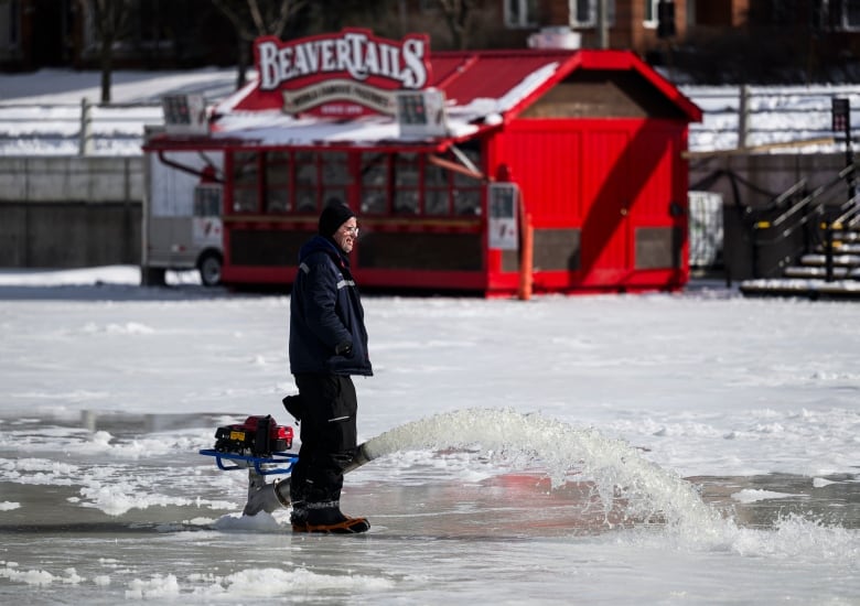 worker spraying water on ice