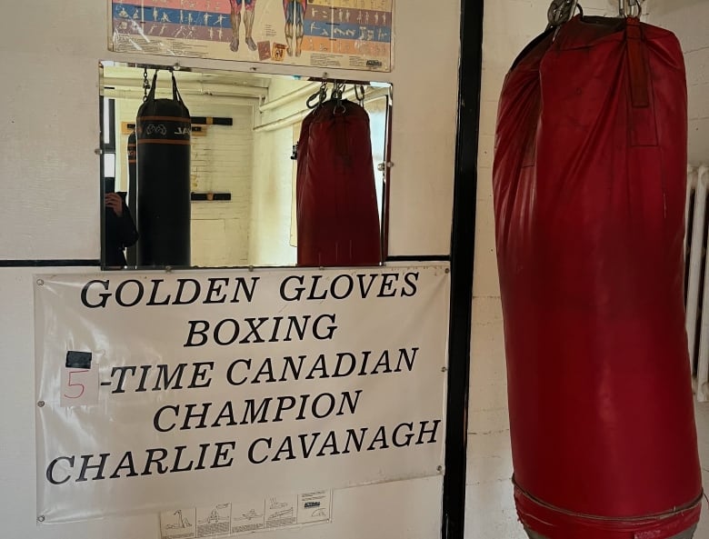 A sign next to a punching bag reads "Golden Gloves Boxing 5-Time Canadian Champion Charlie Cavanagh"