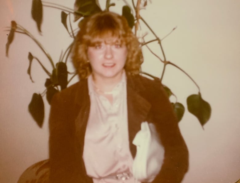 Sepia-toned photo of a young woman with curly hair. 