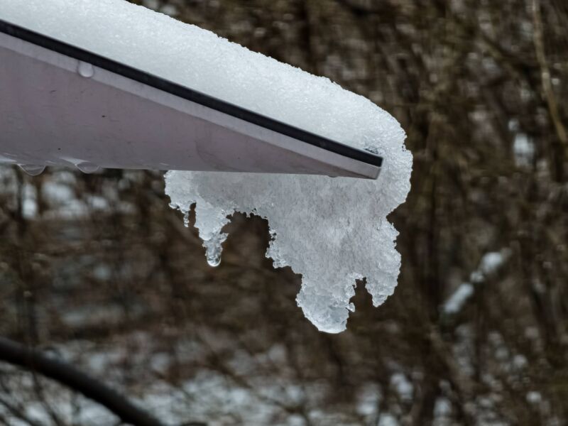 Snow and ice cover part of a Starlink satellite dish.