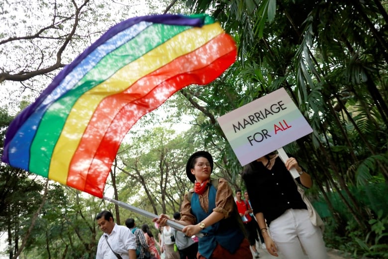 A parade participant waves a Pride flag.