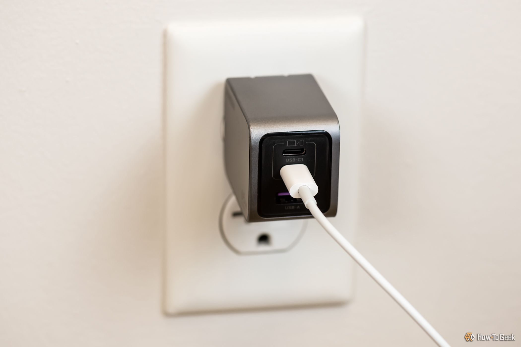 The Ugreen Nexode Pro 65W USB-C Wall Charger plugged into a wall outlet