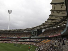 FILE - Spectators make their way home after play had been suspended due to heavy rain during the second day of the first cricket test match between Australia and South Africa at the Gabba stadium in Brisbane, Australia, on Nov. 10, 2012. Brisbane Olympics organizers have been advised to consider building a new stadium on a greenfield site near the city's downtown and scrap plans to demolish and rebuild a century-old cricket stadium as the centerpiece for the 2032 Games.