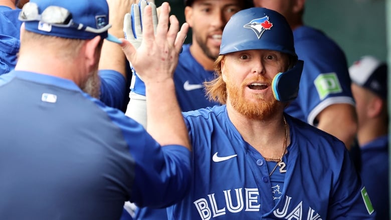 Toronto Blue Jays infielder high-fives the manager while walking in the dugout during a March 21, 2024 pre-season game in Bradenton, Fla.