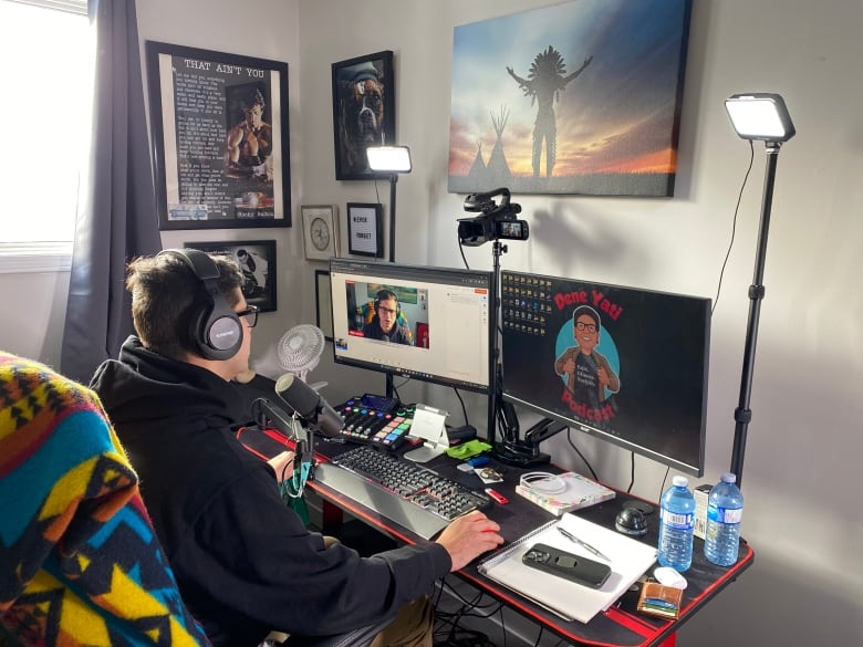 a person is sitting in front of their computer screen, while wearing headphones and speaking into a mic for their podcast.