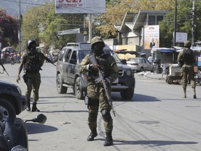 Members of the General Security Unit of the National Palace, USGPN, set up a security perimeter around one of the three downtown stations after police fought off an attack by gangs the day before, in Port-au-Prince, Haiti, Saturday, March 9, 2024.