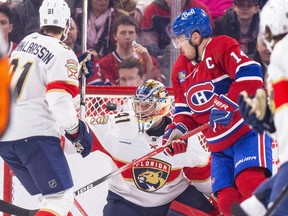 Canadiens' Nick Suzuki deflects the puck past Panthers goalie Anthoney Stolarz and defenceman Oliver Ekman-Larsson for his second goal of the game Tuesday night at the Bell Centre.