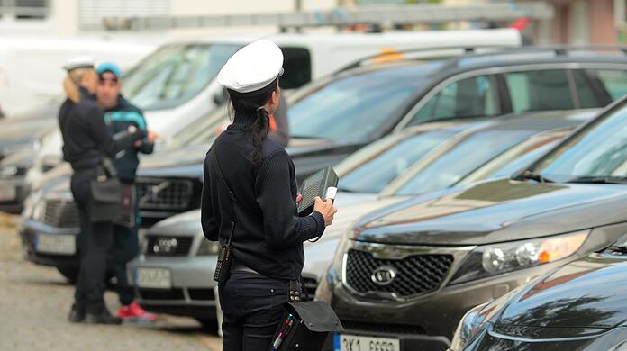 An der Theresienwiese haben Autofahrer falsch geparkt. Eine Polizistin schreibt Strafzettel, die Stadt würde diesen Prozess gerne automatisieren.