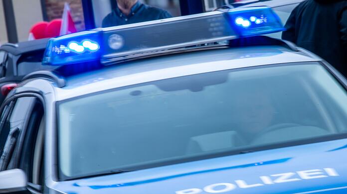 Ein Streifenwagen der Polizei ist mit Blaulicht im Einsatz.