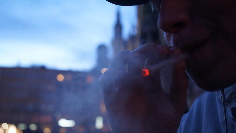 Ein junger Kiffer raucht am Abend des 1. April einen Joint vor dem Rathaus auf dem Marienplatz.