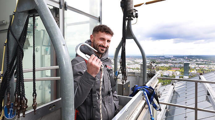 Sicherheit hat oberste Priorität. "Eigentlich darf sich nie Routine einschleichen", sagt Benjamin Bajrovic im Krankorb auf den Highlight Towers. Im Hintergrund: großartiger Ausblick Richtung Allianz Arena.