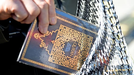 „Die Daten geben Anlass zur Sorge“: Ein Passant steckt einen Koran in die Tasche.