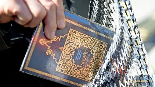 „Die Daten geben Anlass zur Sorge“: Ein Passant steckt einen Koran in die Tasche.