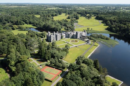 Ashford Castle von oben: Dieses schön gelegene Fünf-Sterne-Hotel bietet viel Komfort. In der Landschaft drum herum kannst du das ein oder andere Abenteuer erleben.