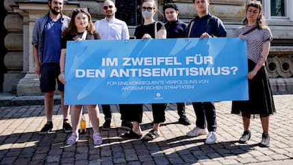 Demonstranten halten vor Beginn eines Prozesses wegen vorsätzlicher Körperverletzung gegen zwei Jugendliche eine Plakat  in die Höhe.