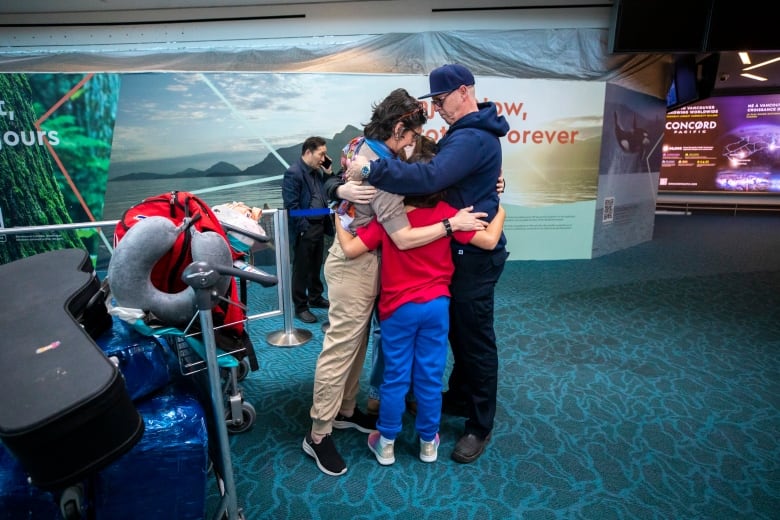 A family hugs at YVR after a four year wait.