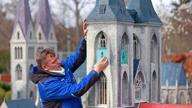 Freizeit: Mitarbeiter des Miniaturenparks Kleiner Harz stellen ein Modell der Martinikirche Halberstadt auf.