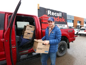 Landon Johnston with boxes of petition signatures to recall Mayor Jyoti Gondek at the Elections Calgary office