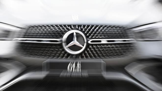 Verbraucher: Das Logo der Automarke Mercedes-Benz ist an der Front eines Mercedes-Benz Fahrzeugs angebracht (Wischeffekt durch Langzeitbelichtung und Zoomen).