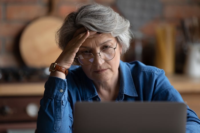 Frustrated person looking at laptop.