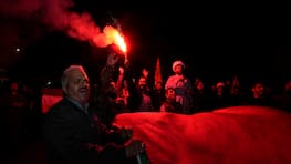 14.04.2024, Iran, Teheran: Ein iranischer Demonstrant zündet eine Fackel, während andere eine palästinensische Flagge während einer anti-israelischen Versammlung auf dem Felestin (Palästina) Platz tragen. Der Iran hat erstmals Israel direkt angegriffen. Trotz internationaler Warnungen schickte der Iran Drohnen und Raketen. Foto: Vahid Salemi/AP +++ dpa-Bildfunk +++